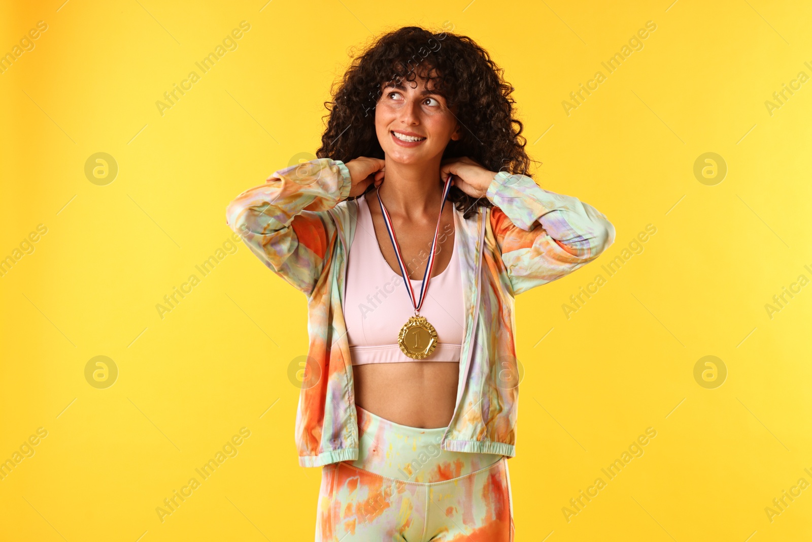 Photo of Happy winner with golden medal on yellow background