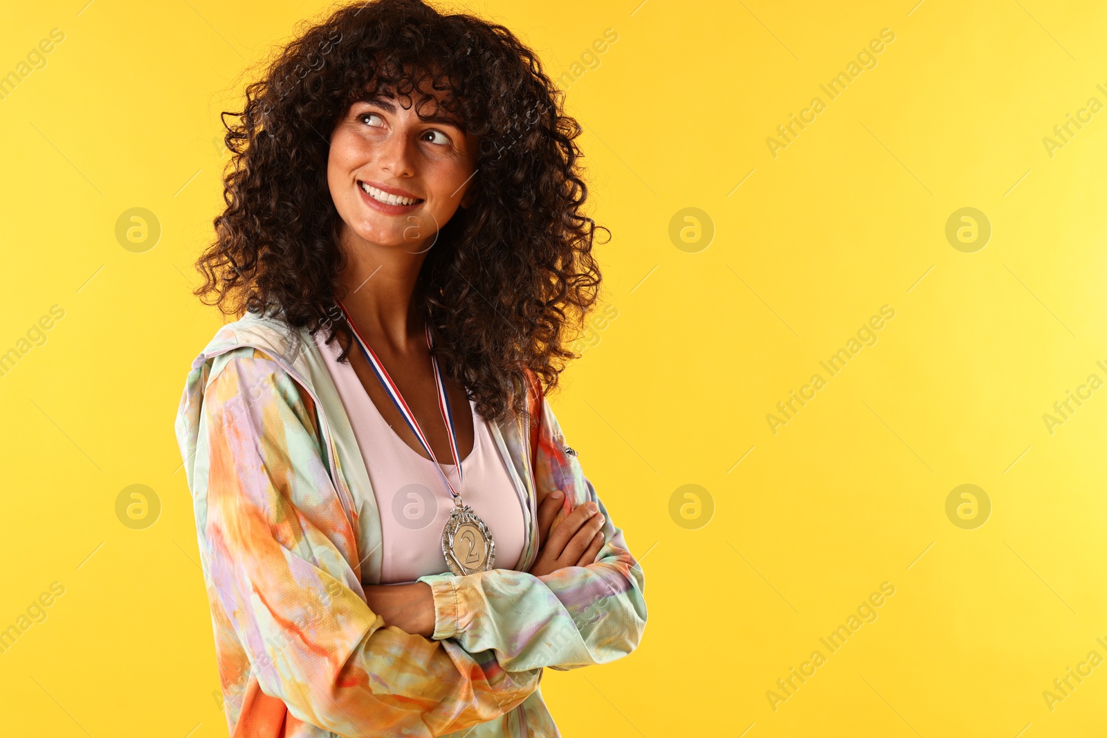 Photo of Happy winner with silver medal on yellow background. Space for text