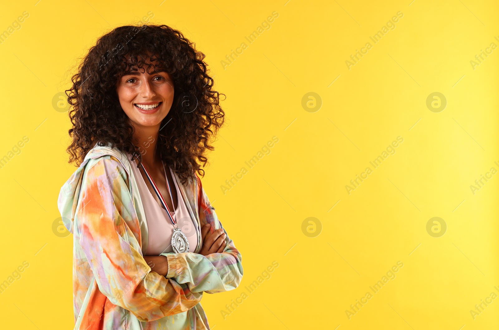 Photo of Happy winner with silver medal on yellow background. Space for text