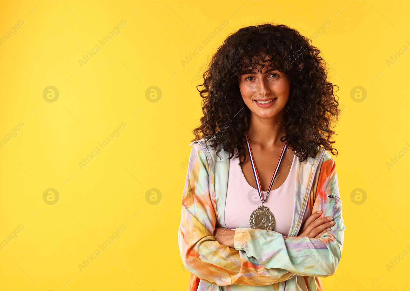 Photo of Happy winner with silver medal on yellow background. Space for text