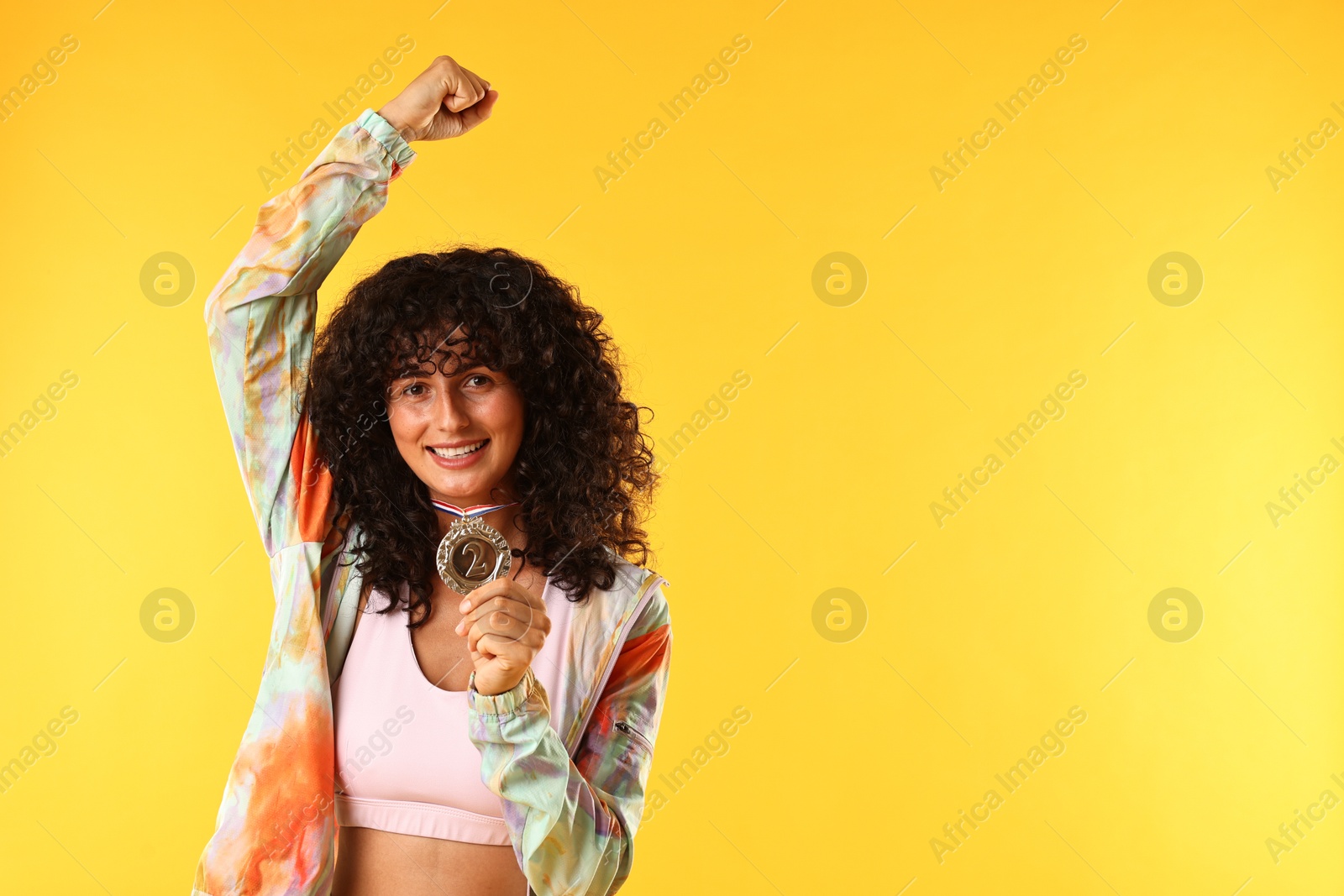 Photo of Happy winner with silver medal on yellow background. Space for text