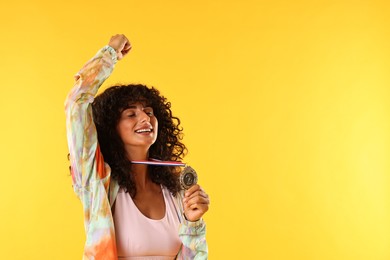 Photo of Happy winner with silver medal on yellow background. Space for text