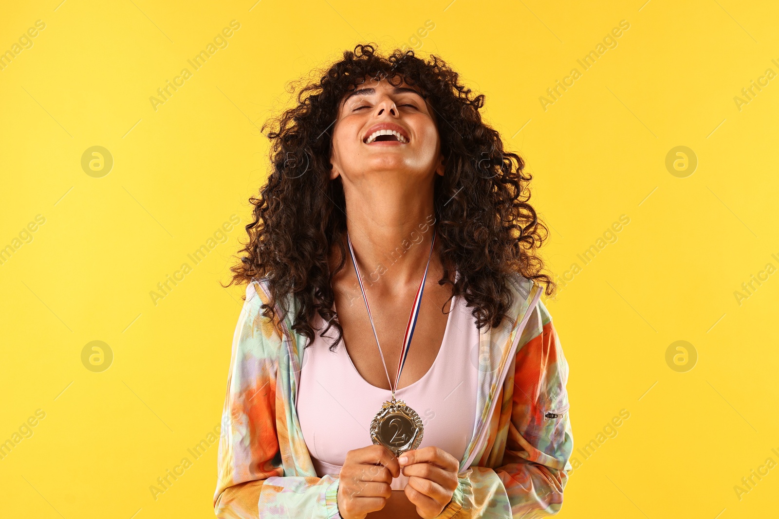 Photo of Happy winner with silver medal on yellow background