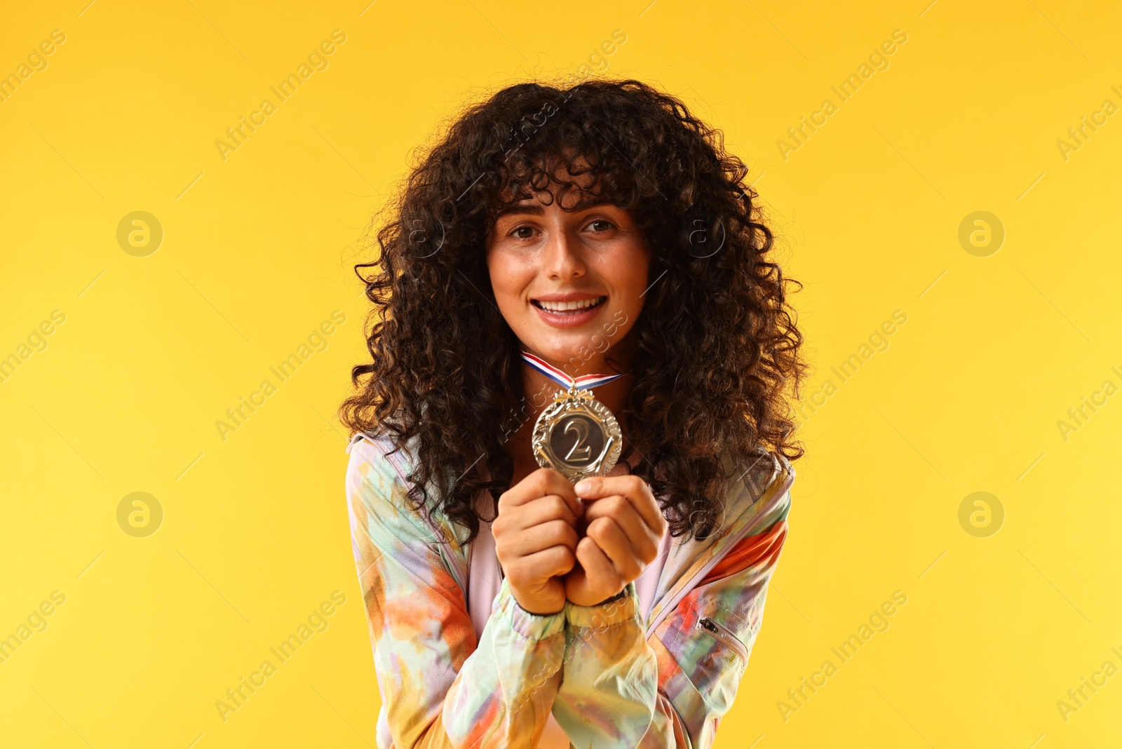 Photo of Happy winner with silver medal on yellow background