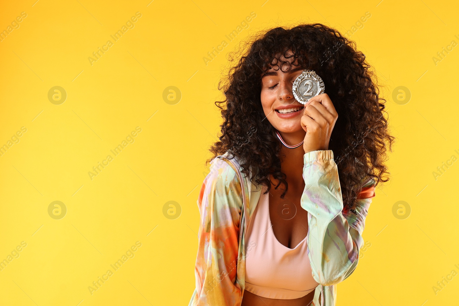 Photo of Happy winner with silver medal on yellow background. Space for text