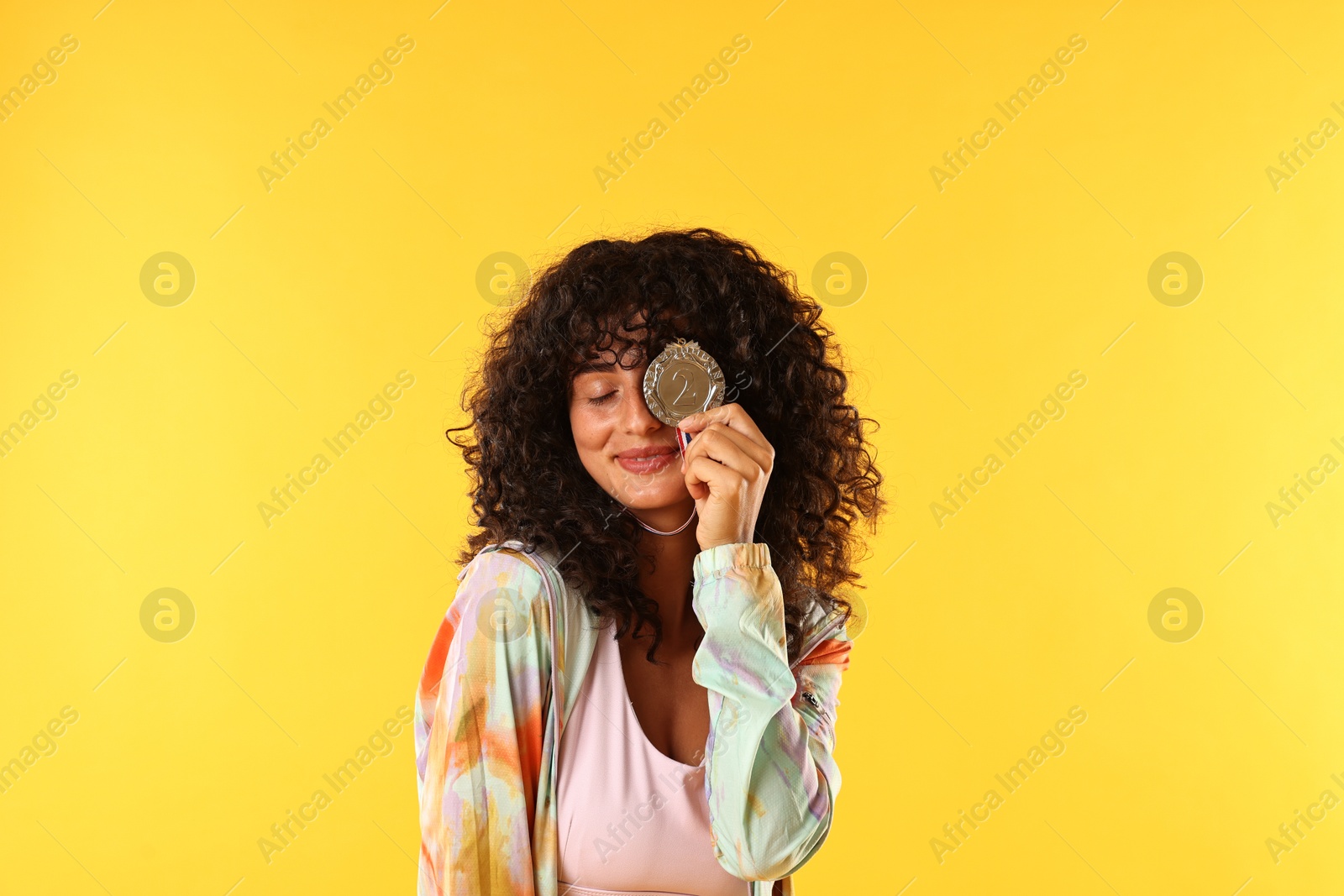 Photo of Happy winner with silver medal on yellow background