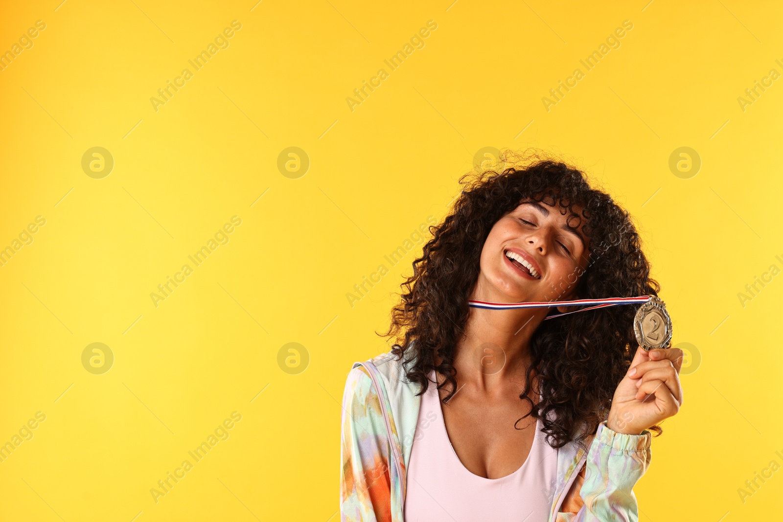 Photo of Happy winner with silver medal on yellow background. Space for text