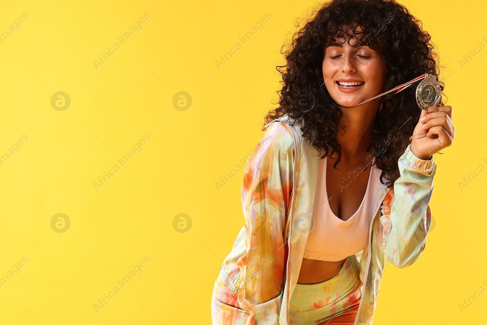 Photo of Happy winner with silver medal on yellow background. Space for text