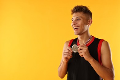 Photo of Happy winner with silver medal on yellow background. Space for text