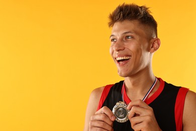 Happy winner with silver medal on yellow background. Space for text