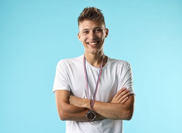 Photo of Happy winner with bronze medal on light blue background