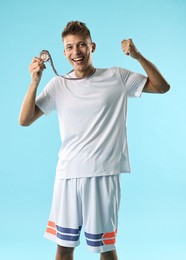 Photo of Happy winner with bronze medal on light blue background