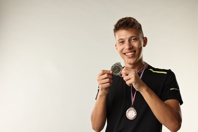 Photo of Happy winner with silver medal on light grey background. Space for text