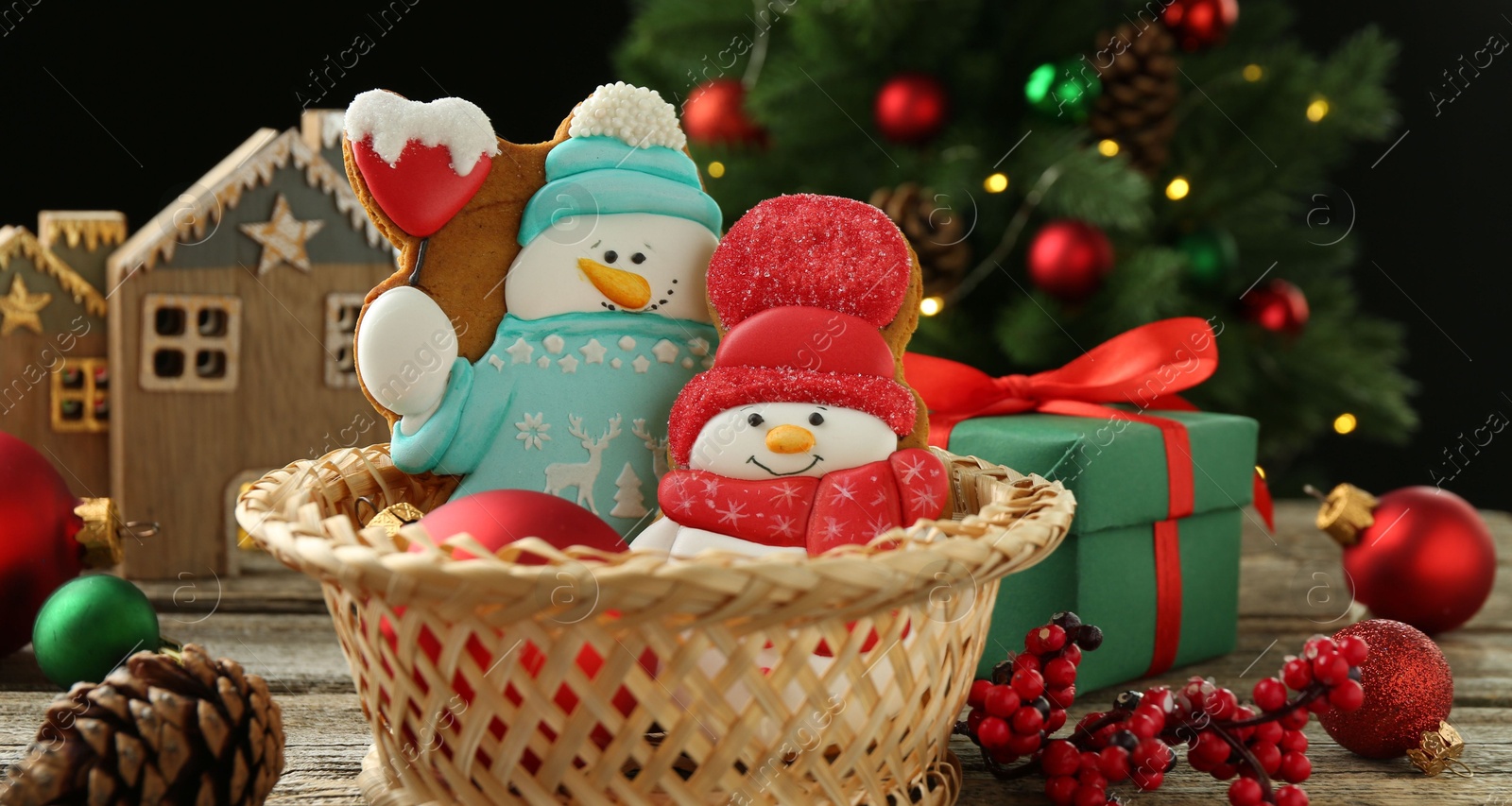 Photo of Delicious cookies in shape of snowmen and Christmas decor on wooden table, closeup