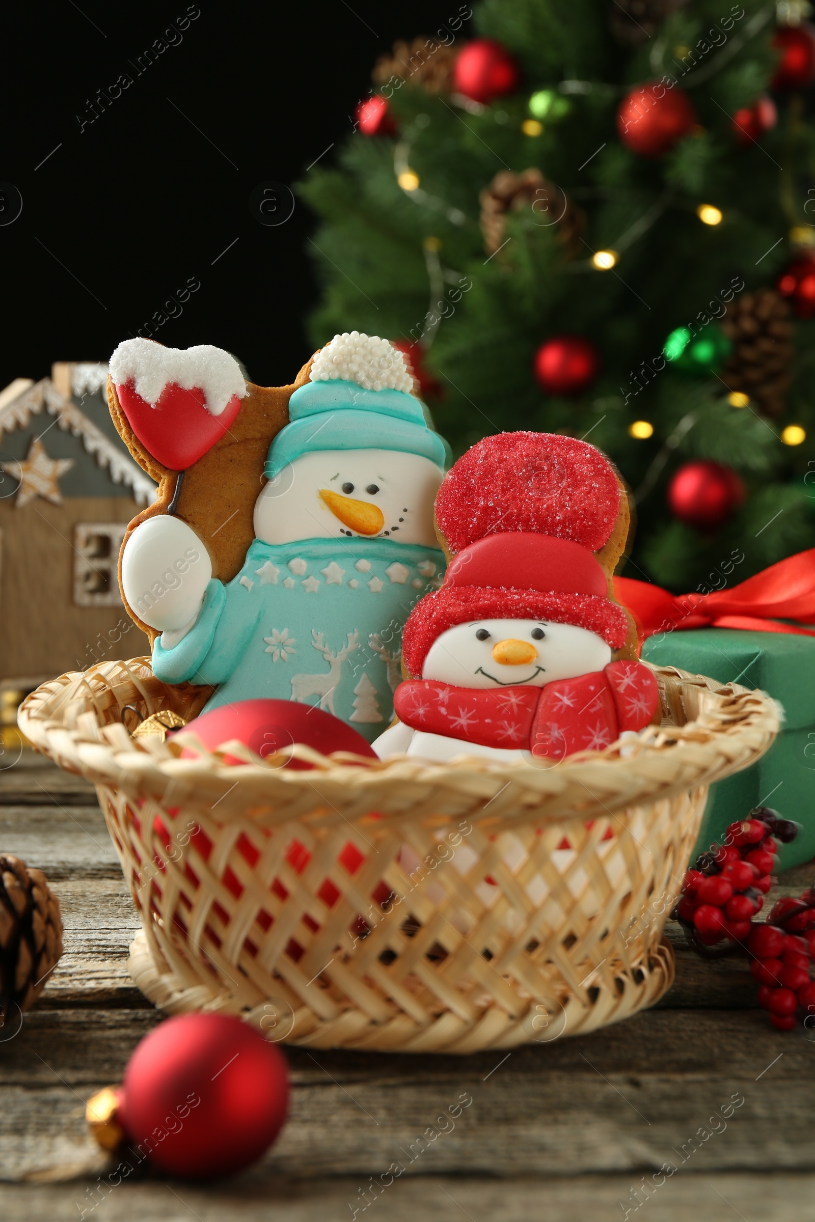 Photo of Delicious cookies in shape of snowmen and Christmas decor on wooden table