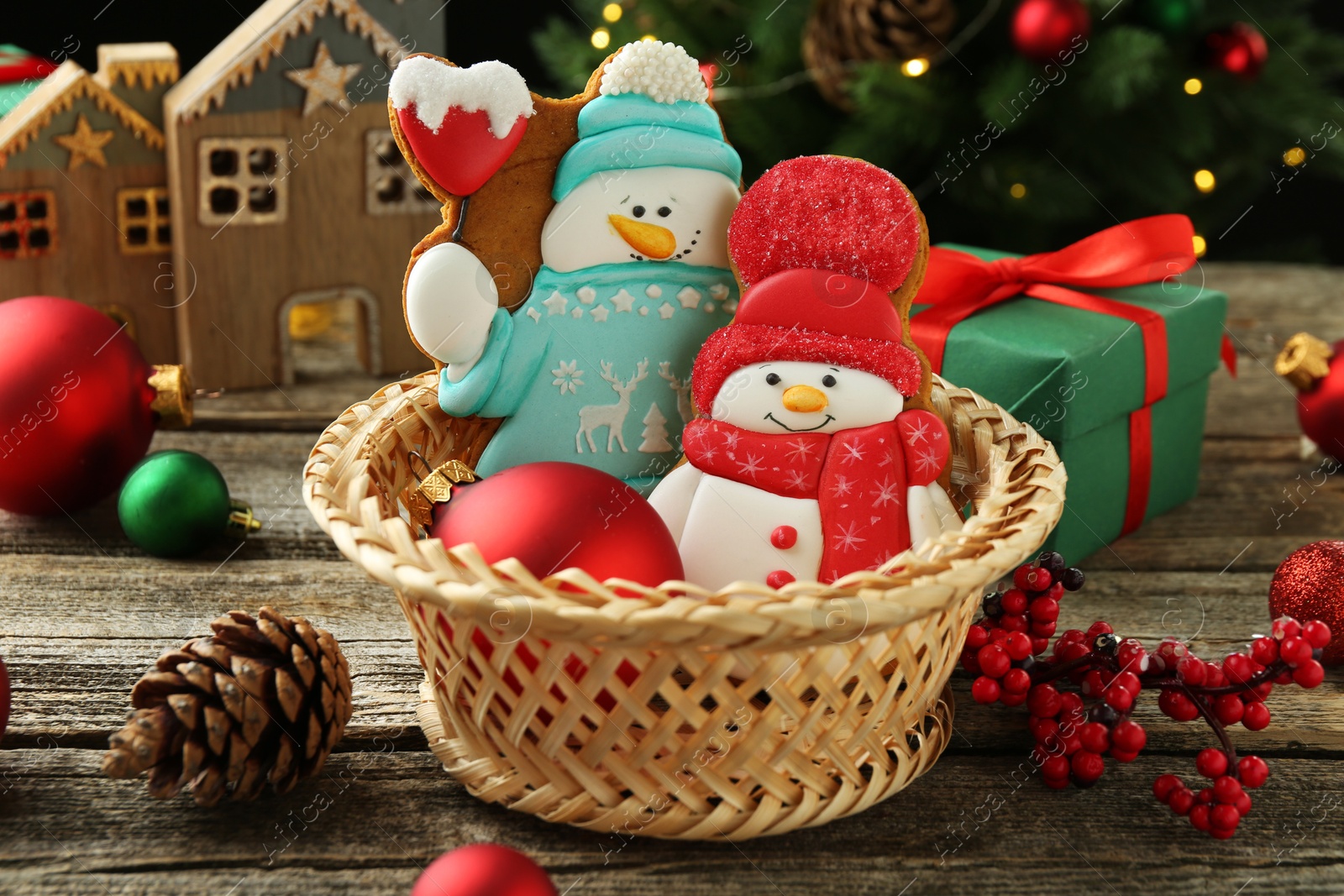 Photo of Delicious cookies in shape of snowmen and Christmas decor on wooden table