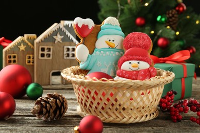 Photo of Delicious cookies in shape of snowmen and Christmas decor on wooden table