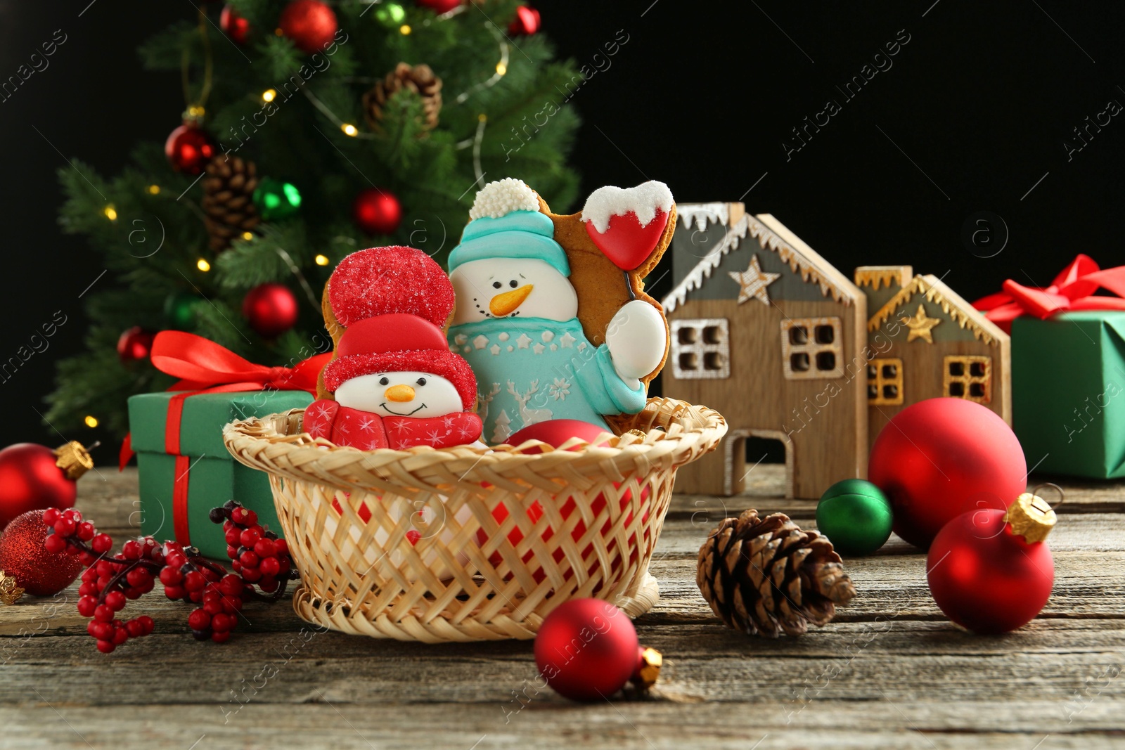 Photo of Delicious cookies in shape of snowmen and Christmas decor on wooden table