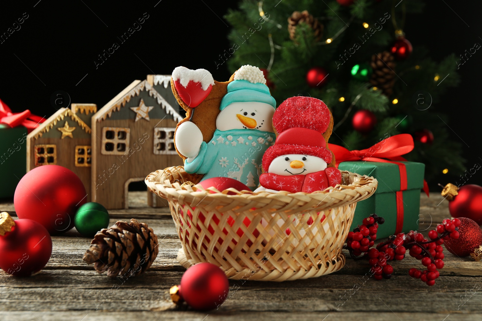 Photo of Delicious cookies in shape of snowmen and Christmas decor on wooden table