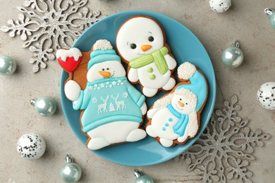 Photo of Delicious cookies in shape of snowmen and Christmas decor on light grey table, flat lay