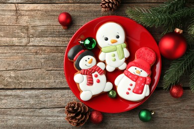 Photo of Delicious cookies in shape of snowmen and Christmas decor on wooden table, flat lay. Space for text