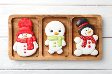 Photo of Delicious cookies in shape of snowmen on white wooden table, top view