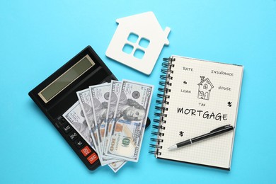 Image of Mortgage. Calculator, dollar bills, house figure and notebook on light blue background, flat lay