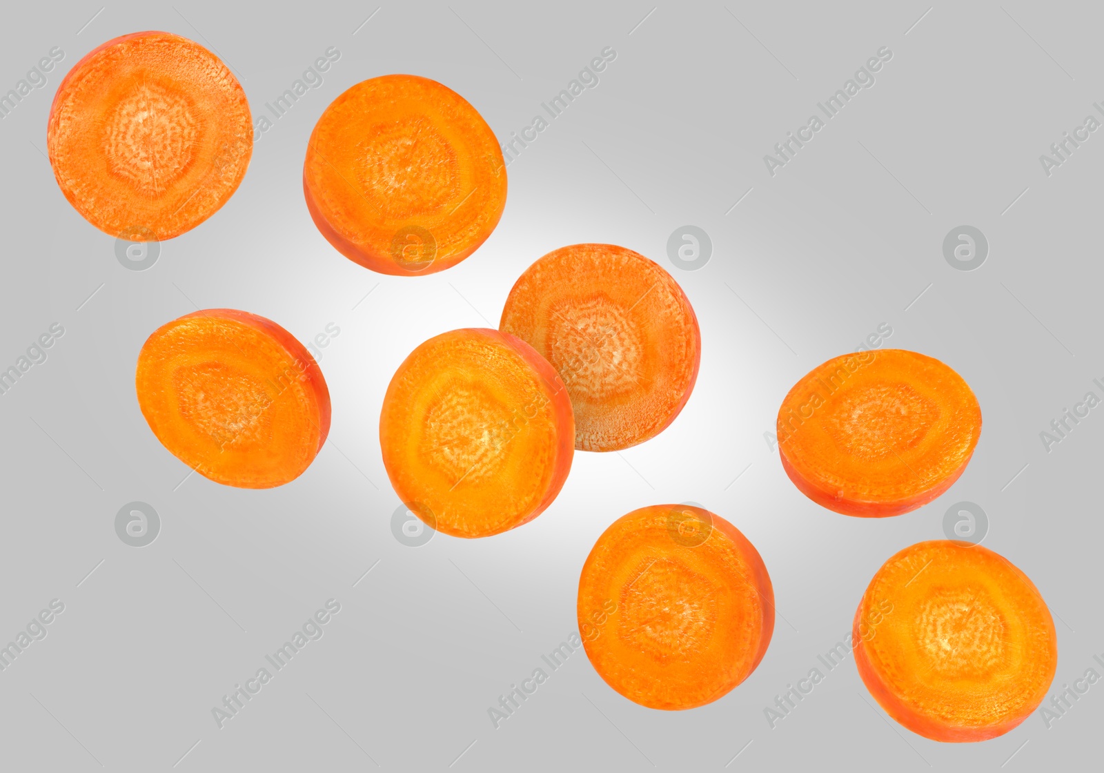 Image of Round carrot slices in air on grey background