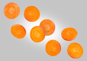 Image of Round carrot slices in air on grey background