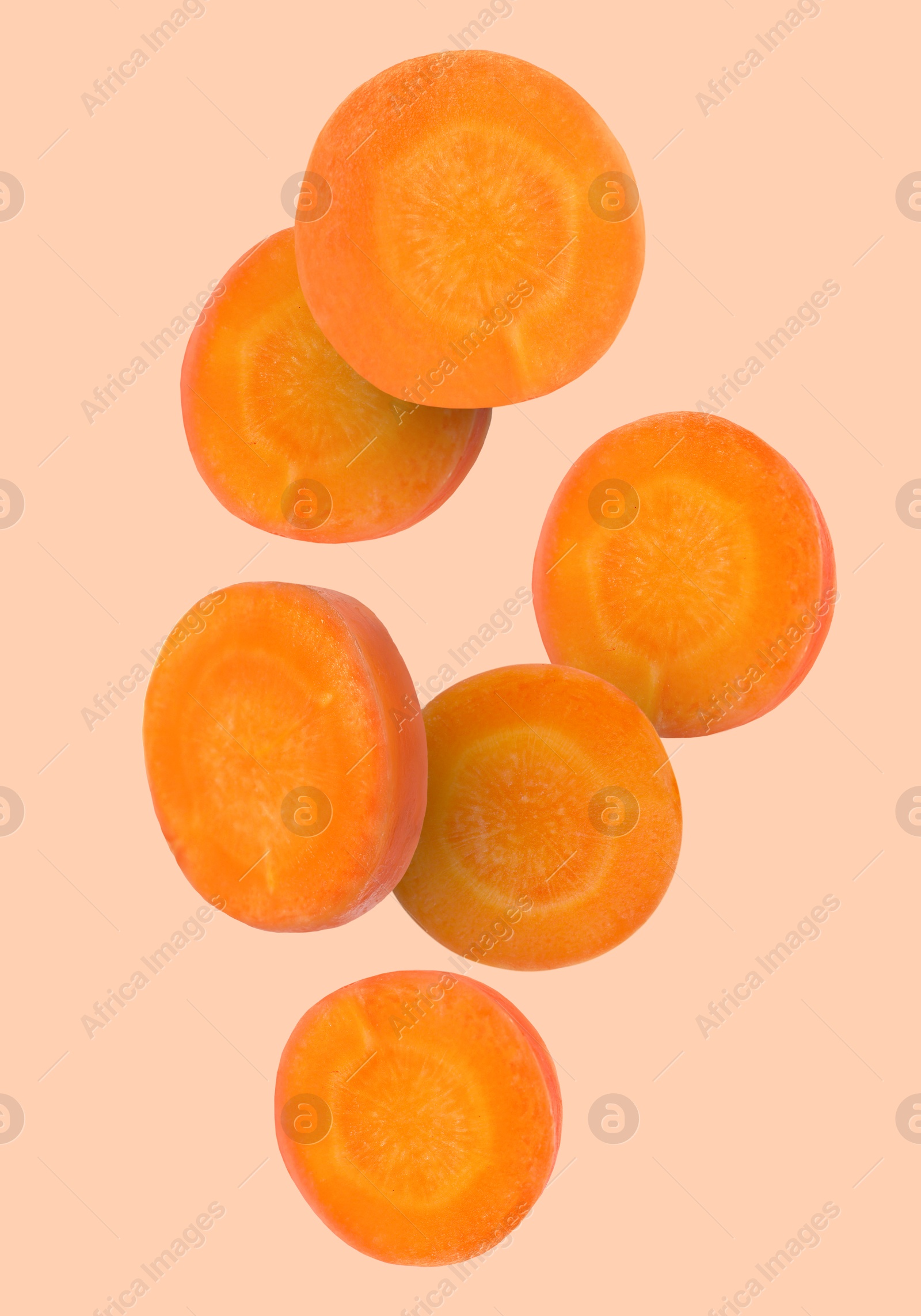 Image of Round carrot slices in air on dark beige background