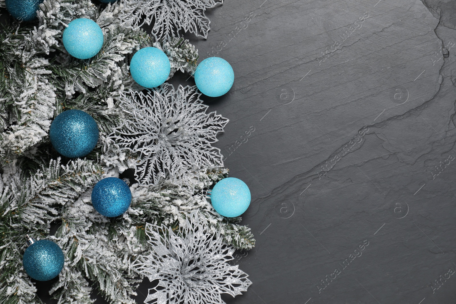 Photo of Different Christmas balls, snowflakes and fir branches with artificial snow on grey textured background, flat lay. Space for text