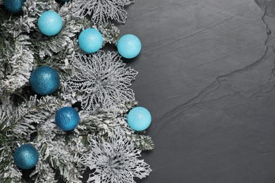 Photo of Different Christmas balls, snowflakes and fir branches with artificial snow on grey textured background, flat lay. Space for text