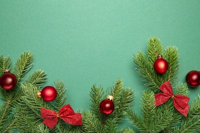 Photo of Fir tree branches with Christmas decor on green background, flat lay. Space for text