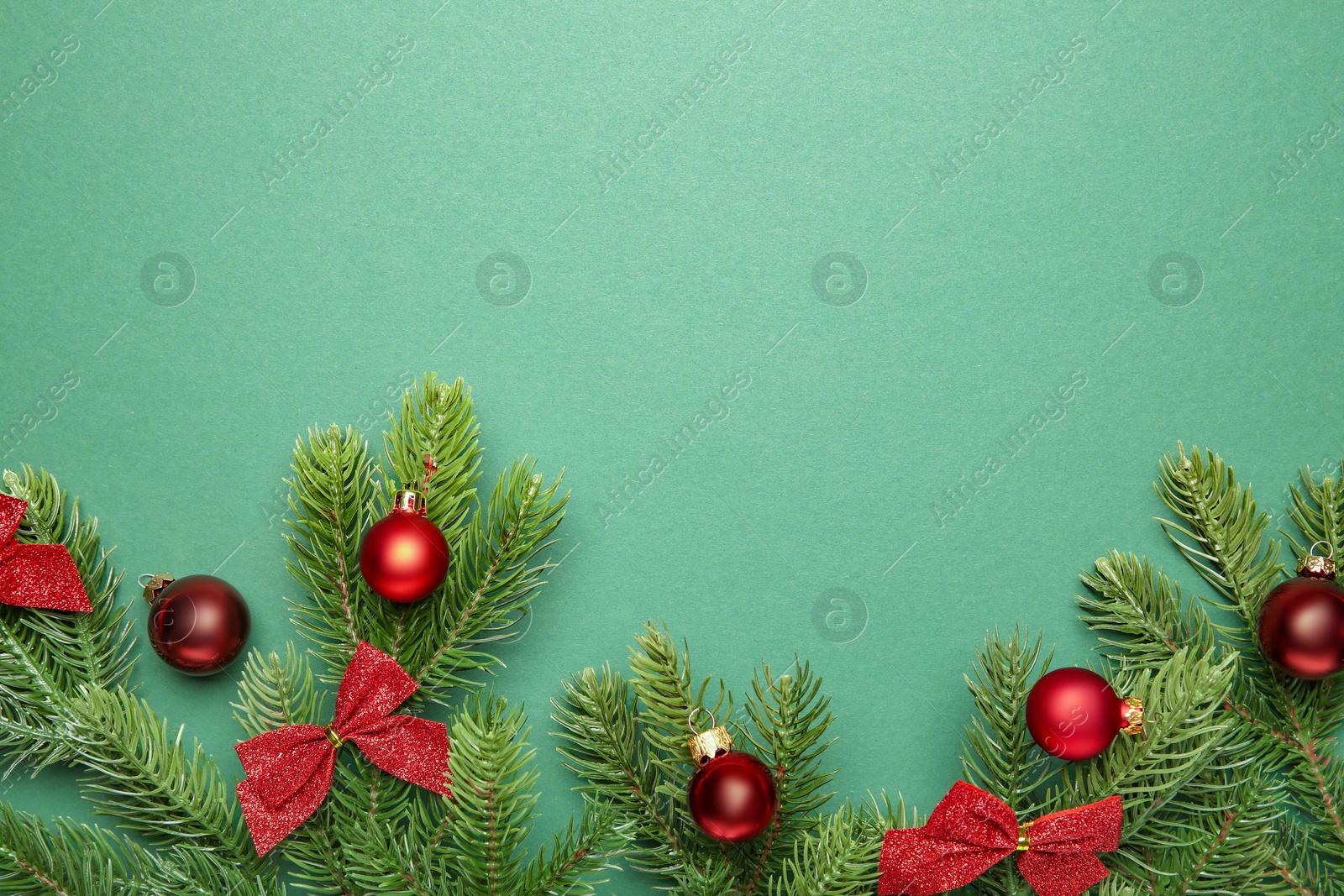 Photo of Fir tree branches with Christmas decor on green background, flat lay. Space for text