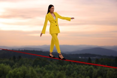 Businesswoman walking rope in mountains. Concept of risk and balance