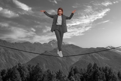 Businesswoman walking rope in mountains. Concept of risk and balance