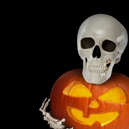 Image of Scary skeleton with spooky jack o'lantern on black background, space for text. Halloween celebration