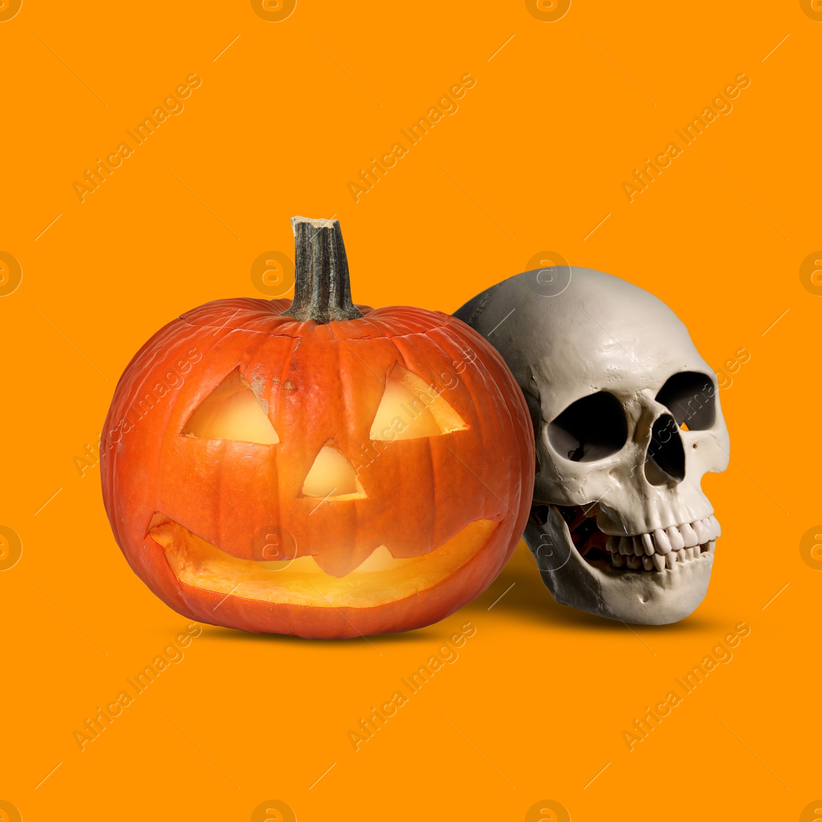 Image of Spooky glowing jack o'lantern and scary skull on orange background. Halloween celebration