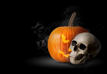 Image of Spooky glowing jack o'lantern and scary skull in smoke on black background, space for text. Halloween celebration