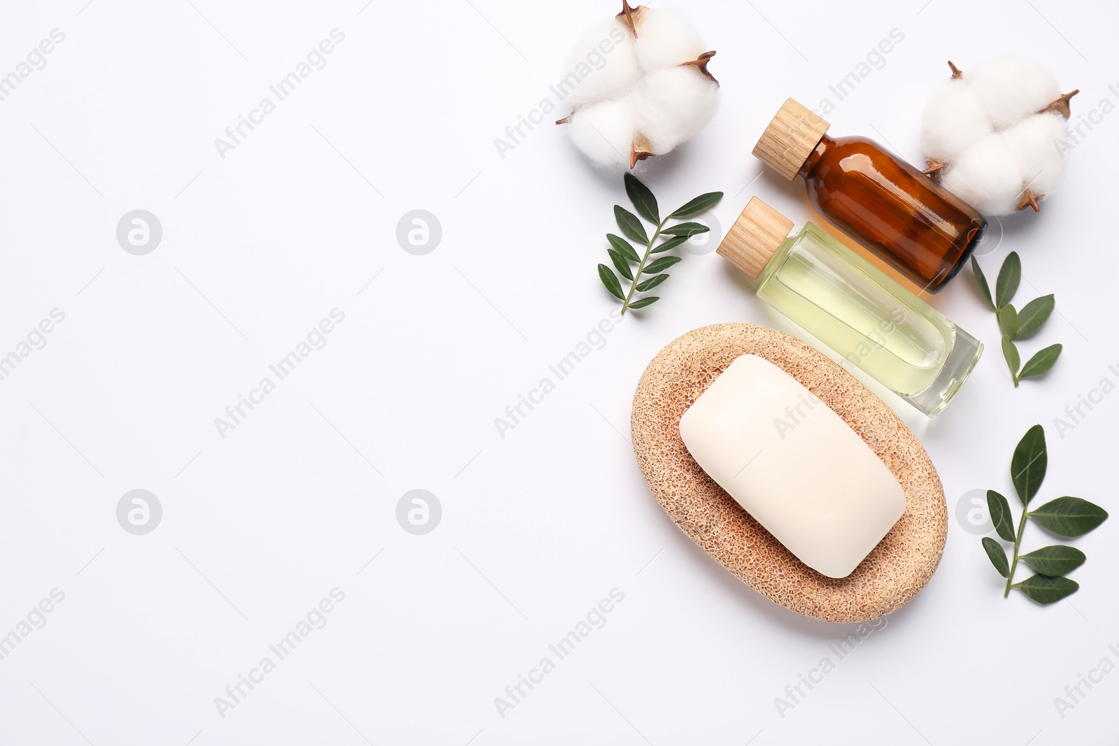 Photo of Different cosmetic products, cotton flowers and leaves on white background, flat lay. Space for text