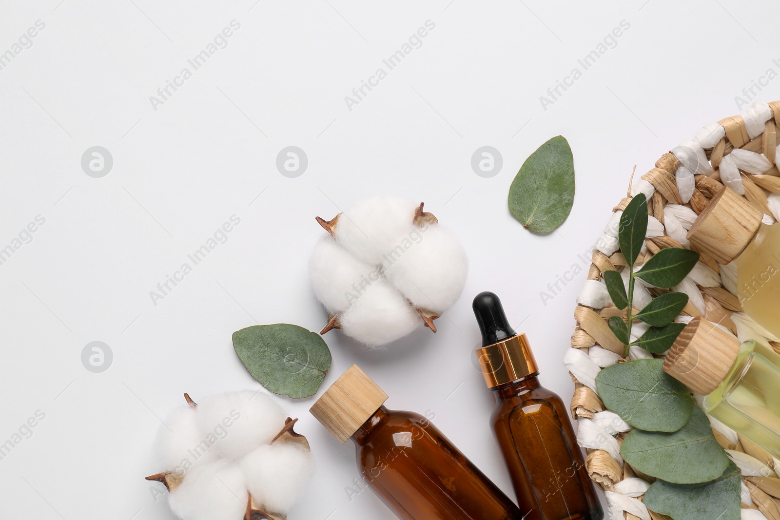 Photo of Different cosmetic products, cotton flowers and leaves on white background, flat lay. Space for text