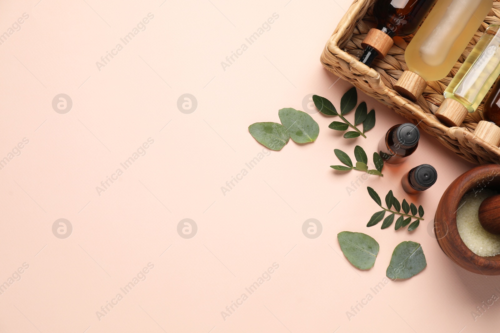 Photo of Different cosmetic products and green leaves on beige background, flat lay. Space for text