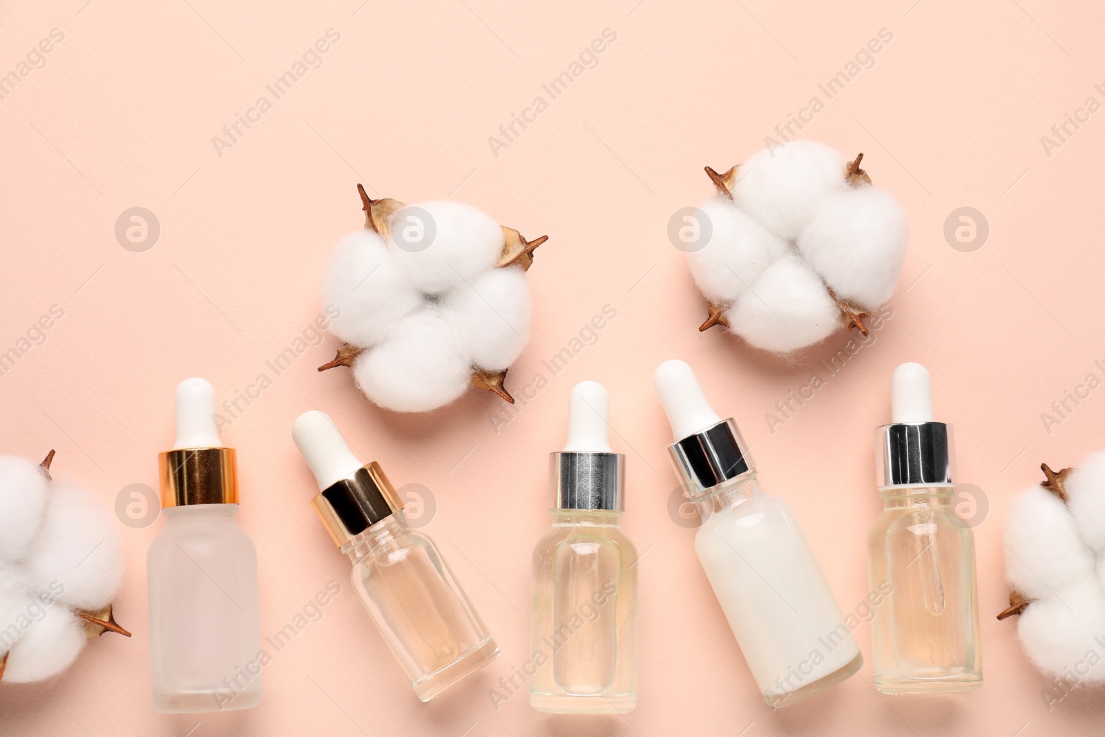 Photo of Different cosmetic product and cotton flowers on beige background, flat lay