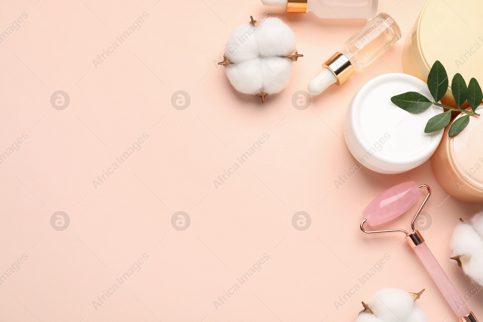 Photo of Different cosmetic products, cotton flowers and leaves on beige background, flat lay. Space for text