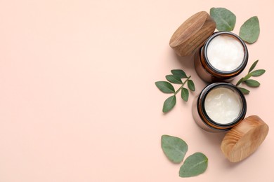 Photo of Different cosmetic products and green leaves on beige background, flat lay. Space for text