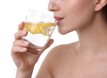 Woman drinking water with lemon on white background, closeup