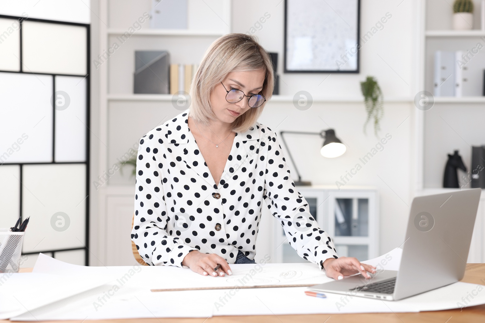 Photo of Architect making engineering drawing at table in office