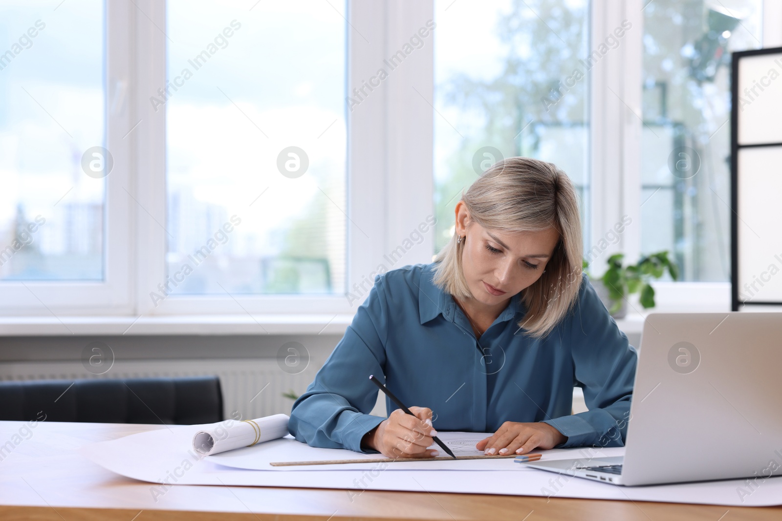 Photo of Architect making engineering drawing at table in office