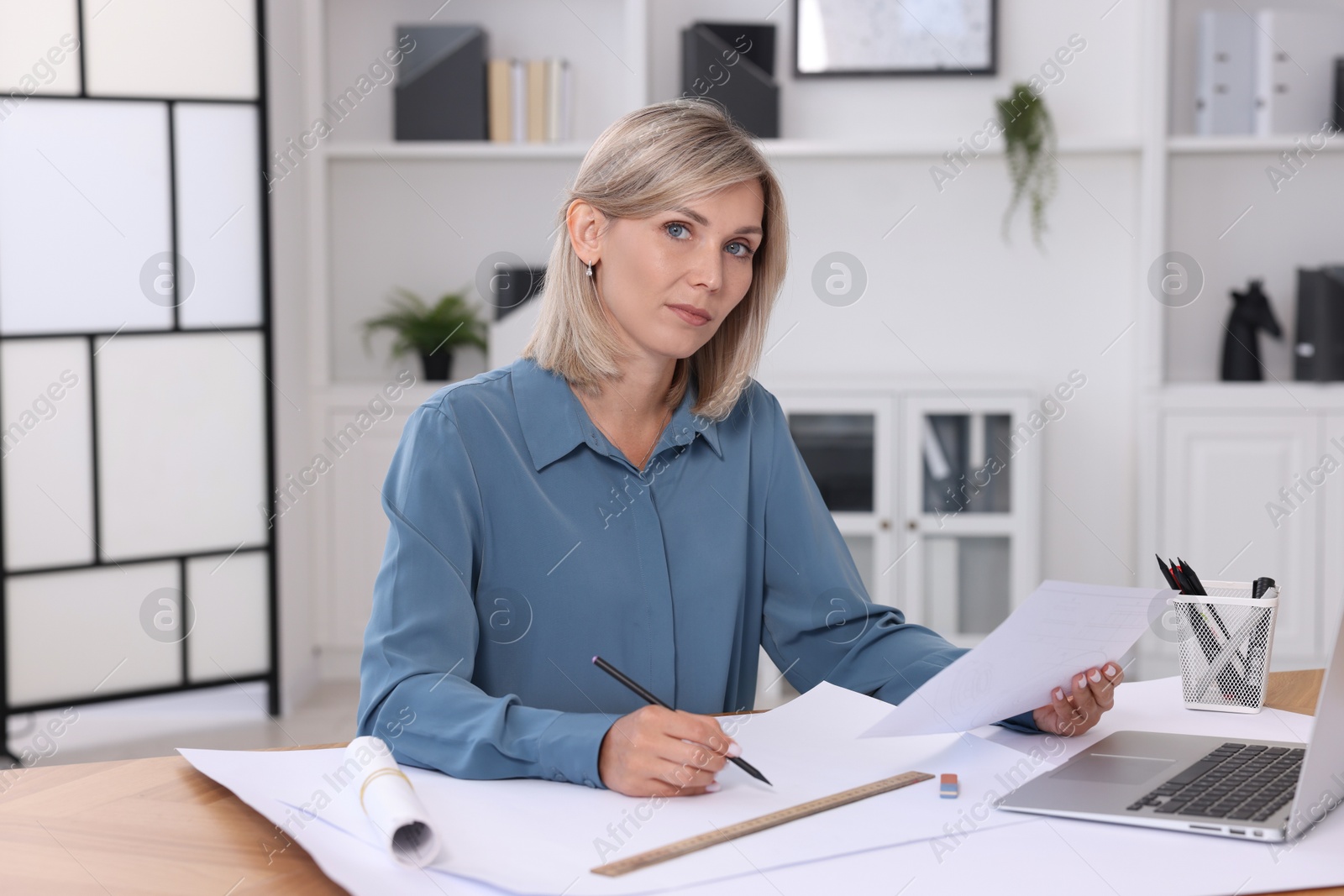 Photo of Architect making engineering drawing at table in office