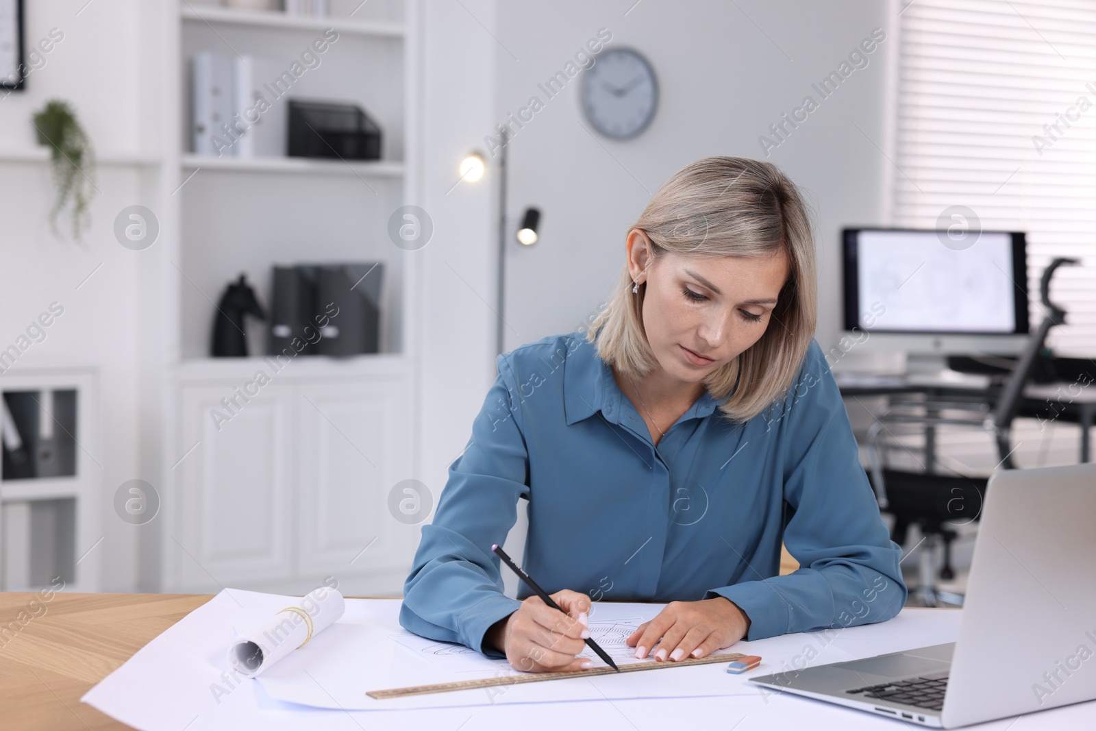 Photo of Architect making engineering drawing at table in office